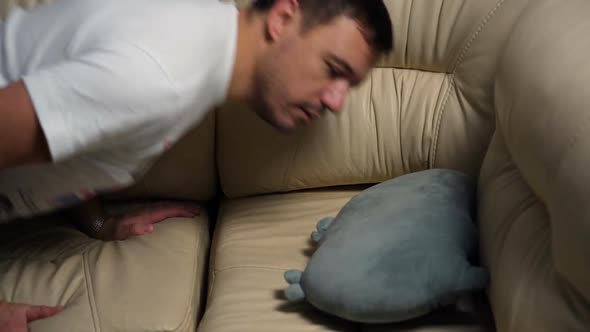 Tired Exhausted Millennial Man Falling Down on Sofa at Home After Hard Working Day Burnout Concept alt