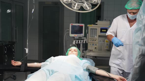 Anesthesiologist Prepares Female Patient for Surgery alt