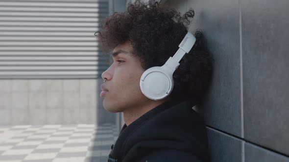 Unhappy Afro American Tourist in Headphones Listening to Music Outdoors Having Fun Alone in the alt