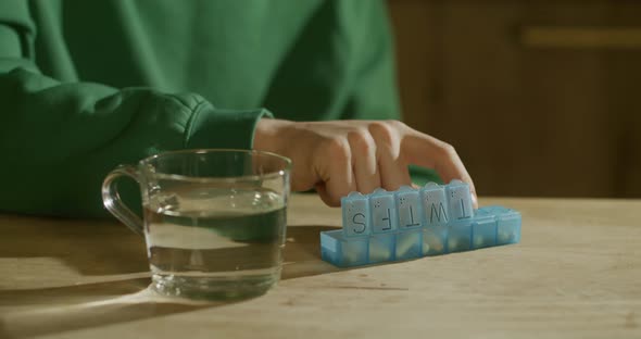 A Man's Hand Closes the Pillbox