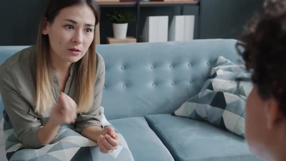 Portrait of Troubled Woman Speaking to Psychotherapist Sharing Feelings Indoors in Office alt