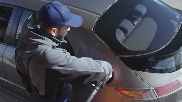 Gas Station Attendant Refueling Customer’s Car alt