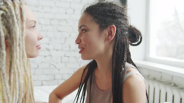 Two Girls Sit on the Bed and Laughing Closeup alt