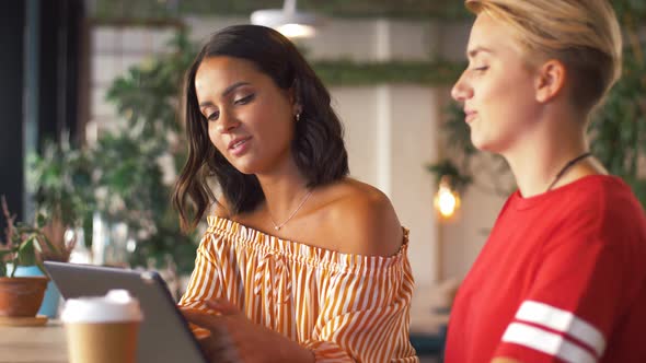 Female Friends with Tablet Pc and Coffee at Cafe alt