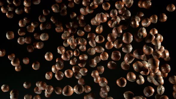 Super Slow Motion Shot of Flying Whole Hazelnuts Towards Camera Isolated on Black at 1000Fps alt