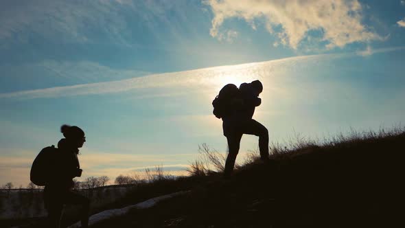 Couple Hiking Help Each Other Silhouette in Mountains. Teamwork Couple Hiking, Help Each Other alt