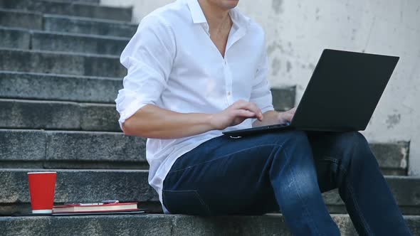 Businessman Sitting On Stairs And Typing On Laptop.