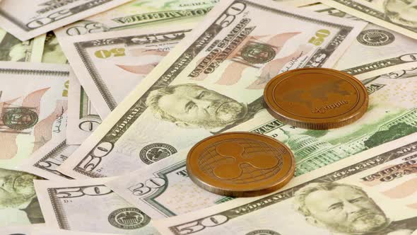 Ripple Coins Rotating on Bills of 50 Dollars. Worldwide Virtual Internet Cryptocurrency. alt