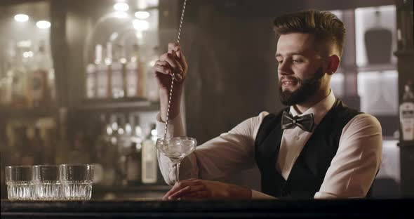 Bartender Is Turning Ice Glass Using Bar Spoon alt