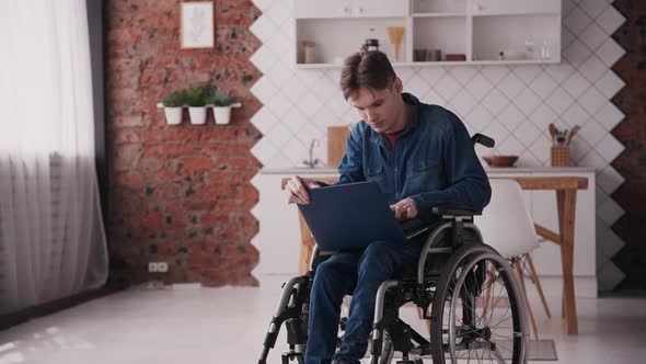 Man in Wheelchair Using Personal Computer at Home