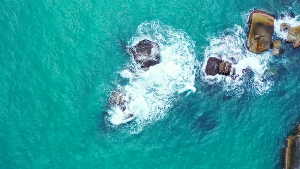 Turquoise sea water and rough waves washing the rocks near the Philippine island coast. alt