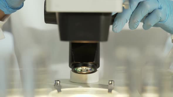 Female Researcher Studying Sample Slide, Moving It to See Better, Medical Test alt