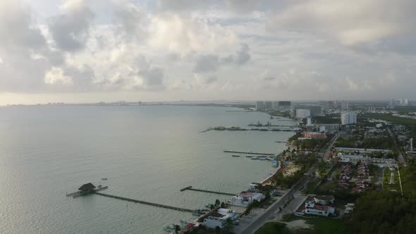 Aerial drone shot over wooden pier on sea water along the coastline of Mexico, North America on a cl alt