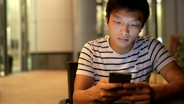 Asian Man Reading on Cellphone 