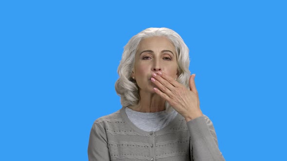 Woman Sending Air Kiss on Color Background alt