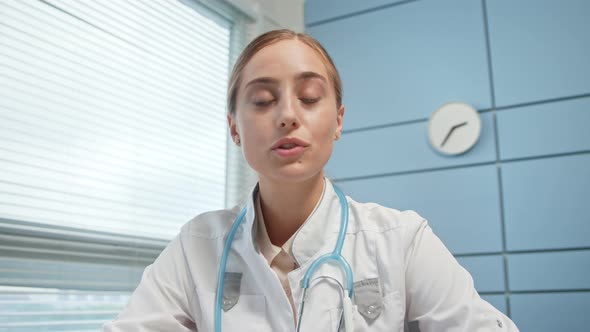 Blonde lady medical blogger in white coat alt