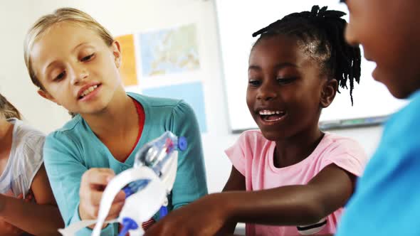 school kids preparing paper craft in classroom alt