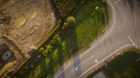 Drone flying over a country road during sunset. alt