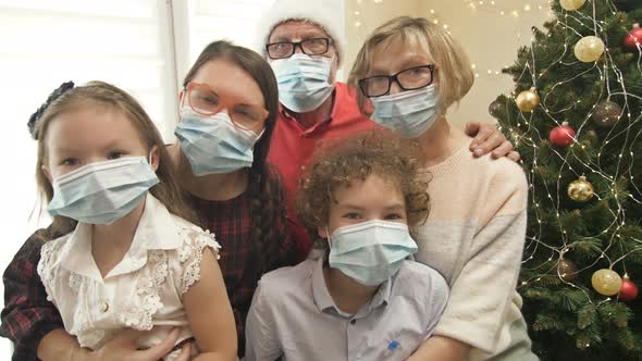 Family Is Celebrating Christmas Wearing Protective Masks. Coronavirus Epidemic, Lifestyle COVID-19 alt