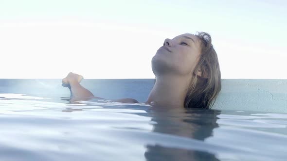 Woman relaxing in swimming pool alt