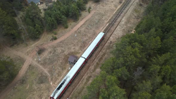 AERIAL: People Boarding Old Train in Remote Forest Location in Eastern Europe alt