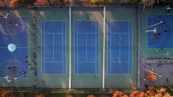 Static overhead view of a group of people playing tennis at Parque Araucano, Las Condes, Santiago, C alt