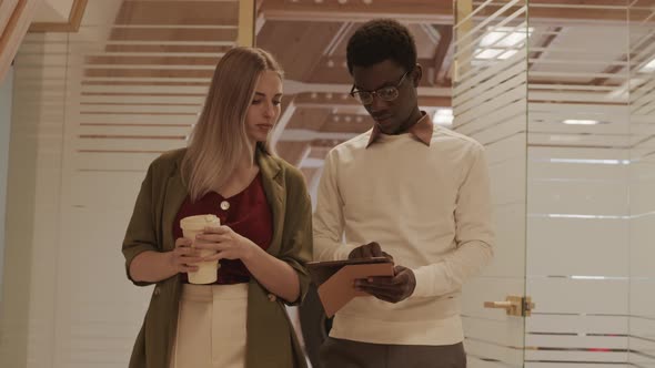 Pair of Diverse Coworkers Going along Office alt