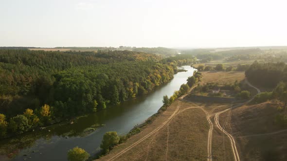 Aerial view. Fenced industrial house on the Bank of a beautiful river. Landscape shot on a drone.