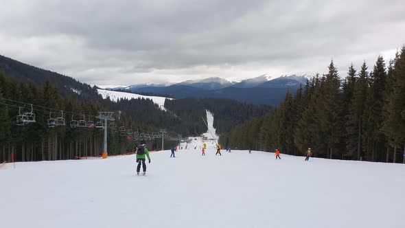 People skiing on the snowy slope of Bukovel ski resort in the Ukrainian Carpathian mountains.