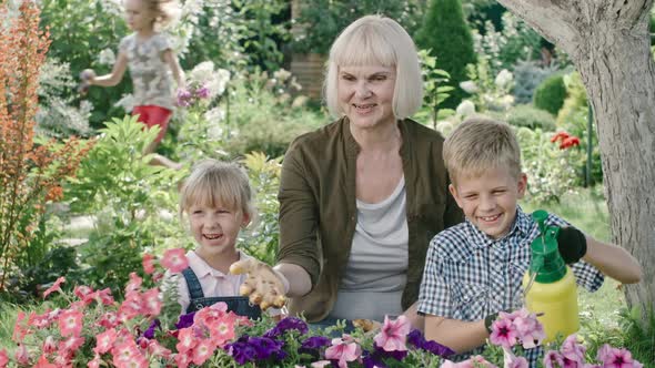 Boy Using Fertilizer Sprayer with Grandmother alt