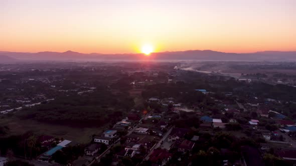 Establishing Aerial View time lapse Shot of sunrise above asia village in morning
