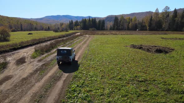 car rides on a rural road around nature forest against a background of a mountain