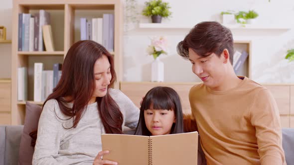 Happy family are sit at couch in the living room. Learning, reading book and prepare for school toge alt