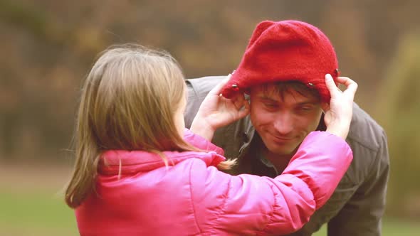 Girl putting her cap on dad's head alt