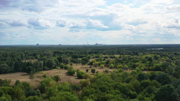 Aerial view of the valley and forest with Reactor 4 Sarcophagus of the Chernobyl Nuclear Powerplant alt