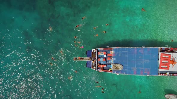 Aerial view of people in ferry diving on the sea, Ithaki island, Greece. alt