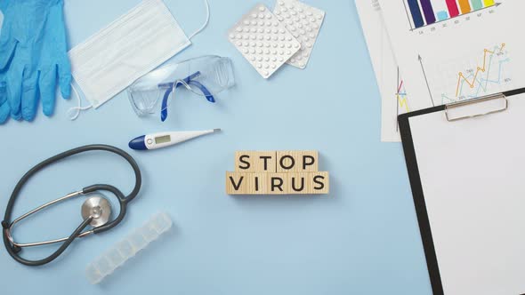 Phrase stop virus of cubes with letters is put by doctor's hands on the medical table. alt