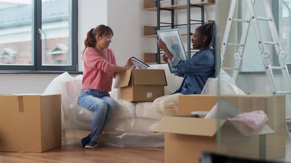 Women Unpacking Boxes and Moving to New Home alt