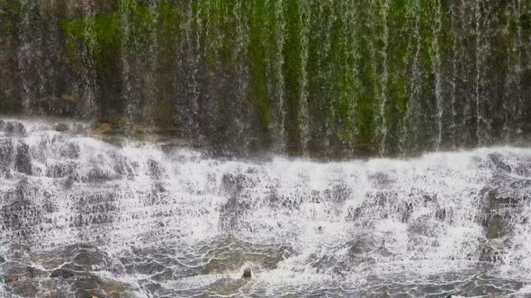 Beautiful scene of water falling over rocks in the water falls at a rain forest alt