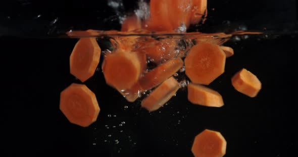 Fall Pieces of Carrot Under Water with Air Bubbles.  alt