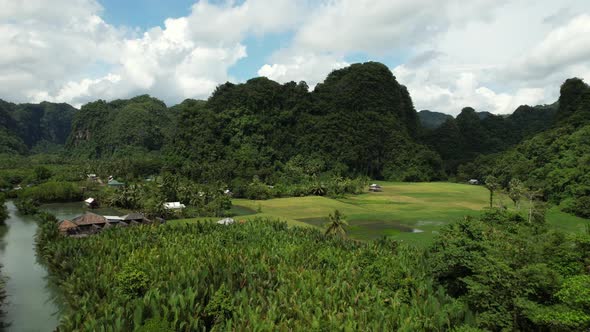 Aerial view of a valley in Ramang Ramang Sulawesi with limestone mountains in the background and a r alt