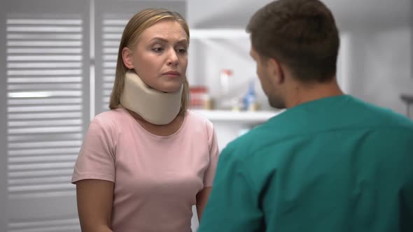 Orthopedist Checking Female Foam Cervical Collar Position, Informing Diagnosis