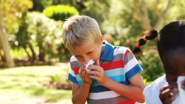 Kids blowing their nose with handkerchief while sneezing alt