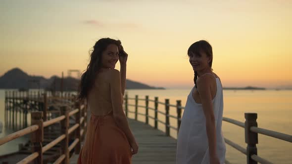 Two Young Women Dressed in the Evening Dress Walking Pier During Sunset on Their Vocation They alt