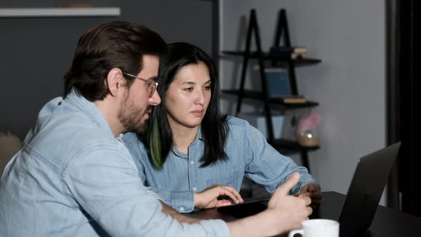A young Man Discusses an online Project With a Colleague, Two Managers Work at Home, Use A laptop alt