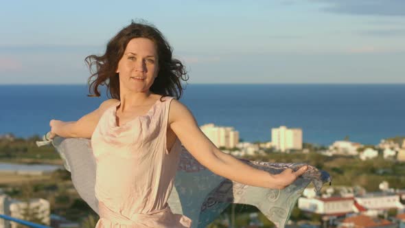 Beautiful Happy Woman Dancing With Scarf, Amazing Sea Landscape in Background alt