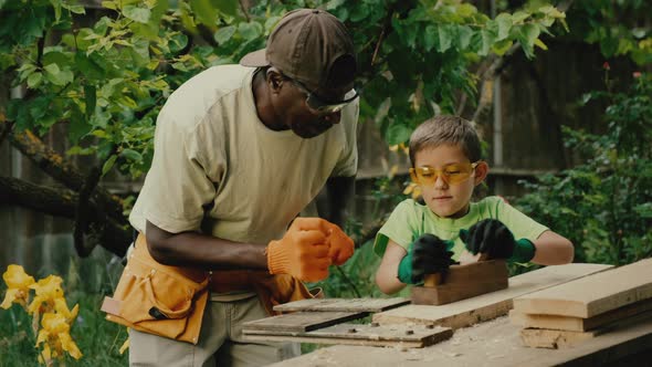 African American Carpenter Gives Lesson to Schooler Boy