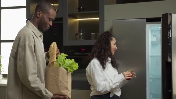 Young Couple Puts Products in Fridge Bought in Grocery Store
