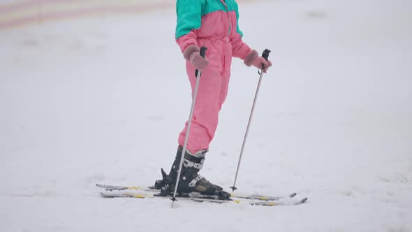 Happy Caucasian Woman Standing on Skis with Ski Poles Looking Around and Smiling alt