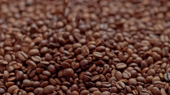 Roasted Coffee Beans Drop in Slow Motion on Full Frame Background of Coffe Beans alt